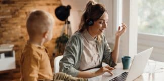 Happy mother having video call over laptop while working at home