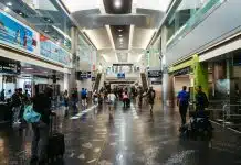 imagem mostra saguão de aeroporto com pessoas circulando entre lojas e franquias em aeroportos