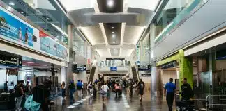 imagem mostra saguão de aeroporto com pessoas circulando entre lojas e franquias em aeroportos